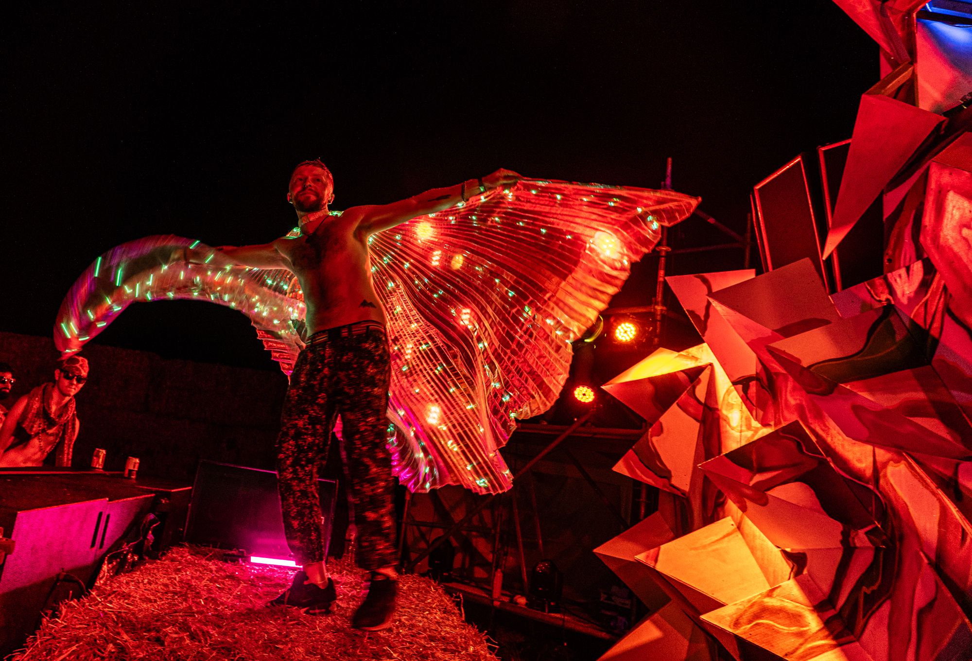 Performer in light-up wings at night