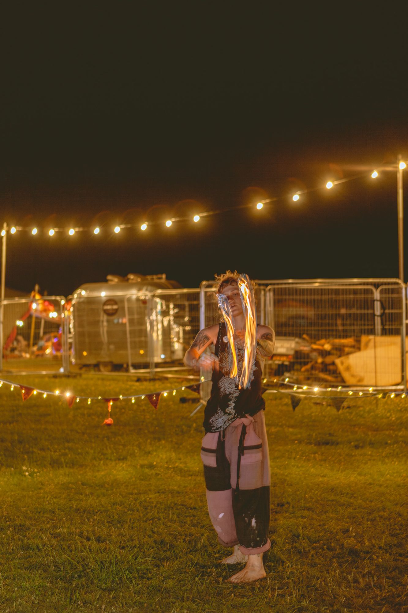 Performer under strings of warm festoon lights at night