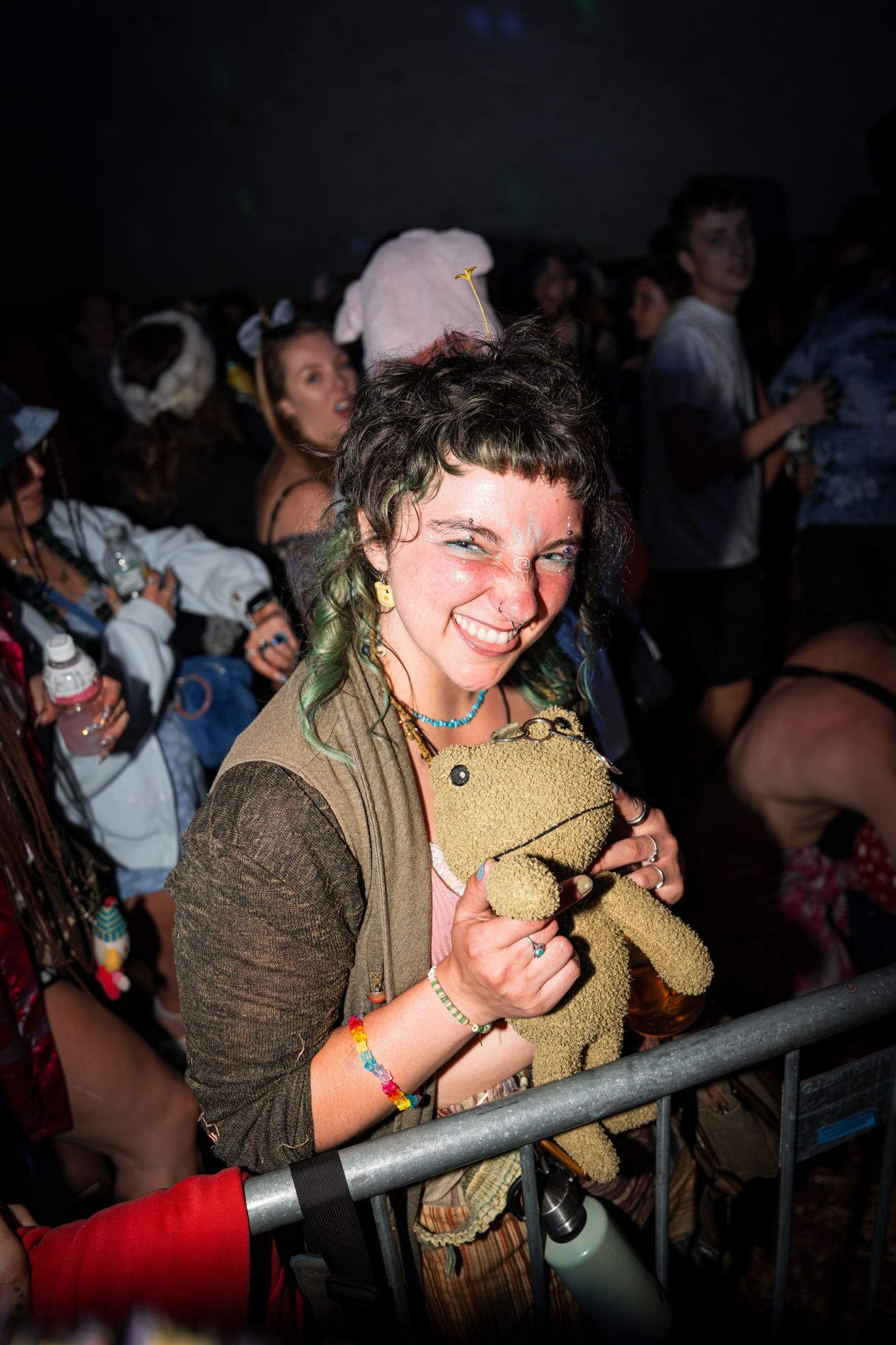 Festival-goer smiling with a plush frog held close